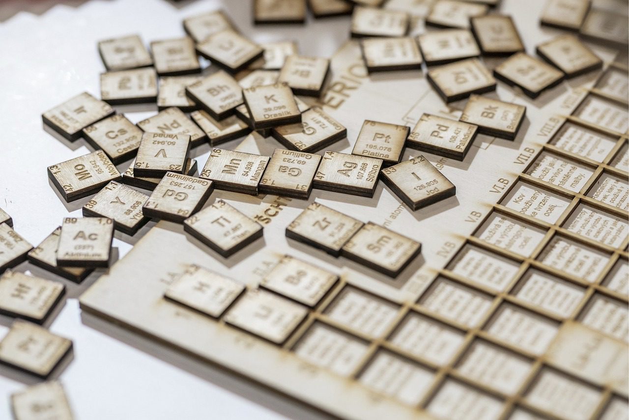 Wooden tiles , scattered and messed up, that represent the periodic table